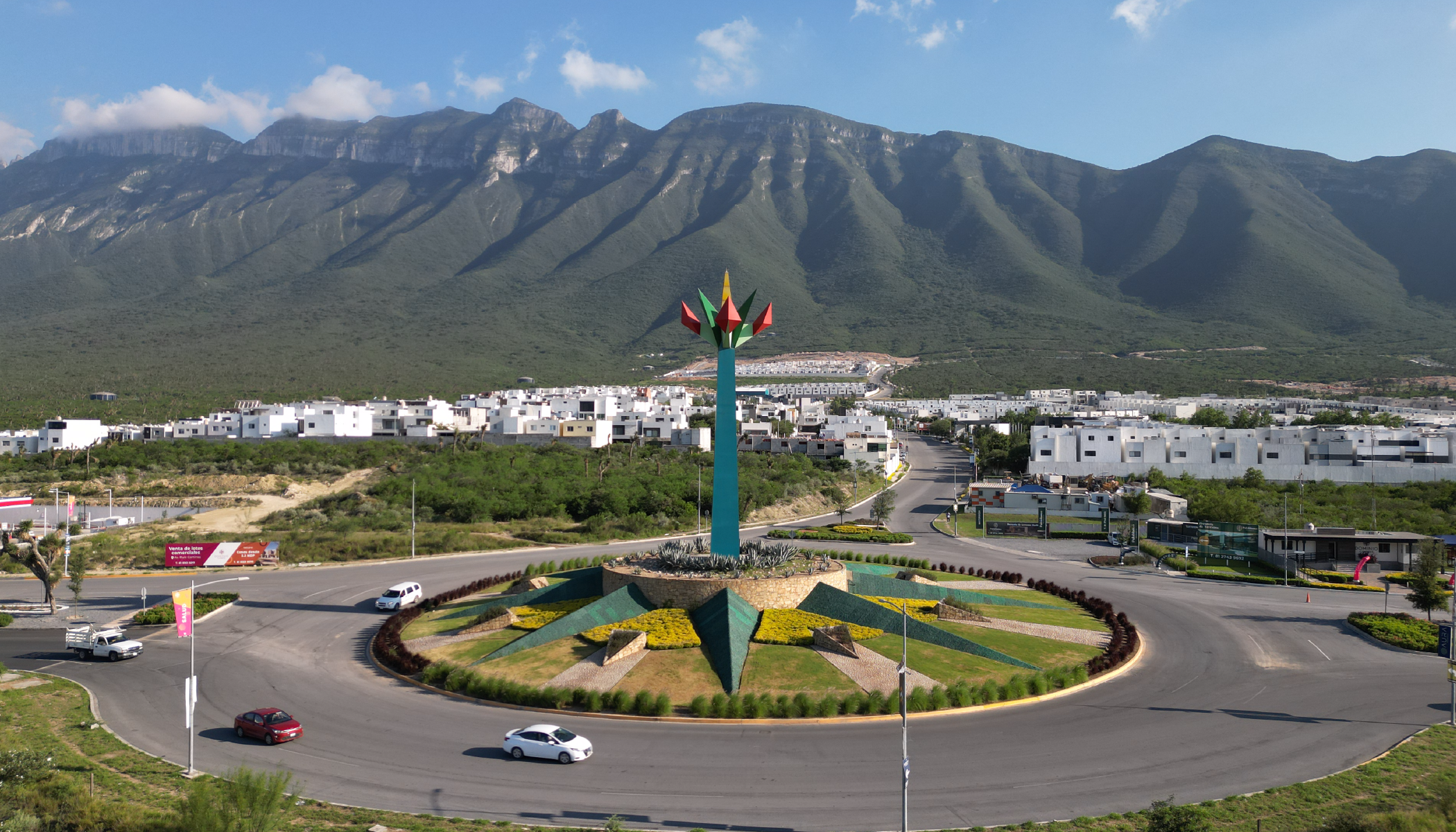 Rotonda con carros circulando y cerro al fondo